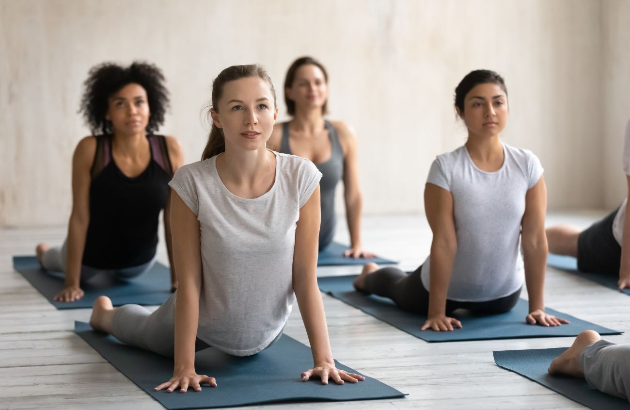 Eine Gruppe an Personen die Yoga praktizieren