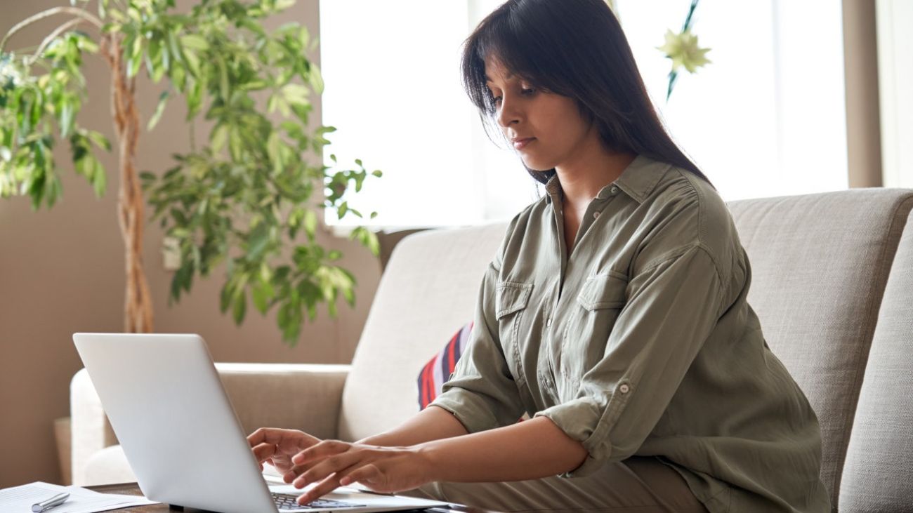 Bewegungsmangel, Frau auf Sofa arbeitet am Laptop