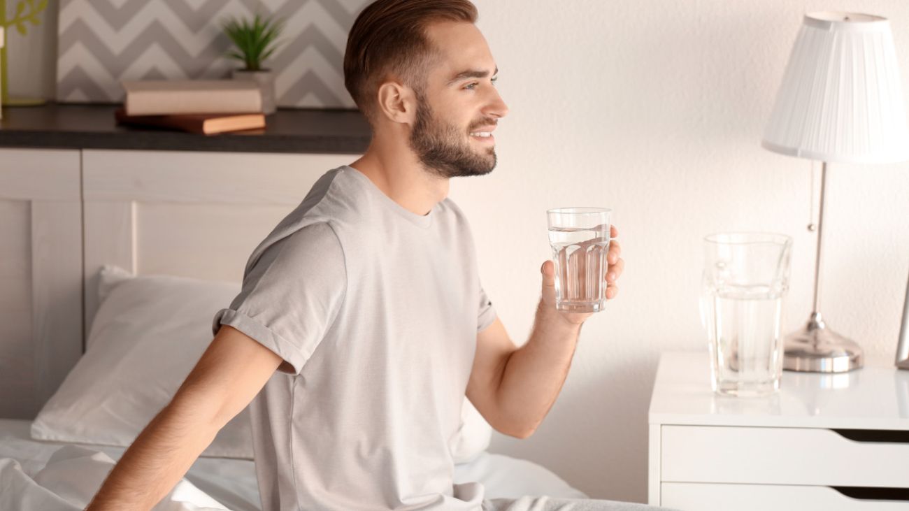 Blähungen abends und nachts, Mann trinkt ein Glas Wasser