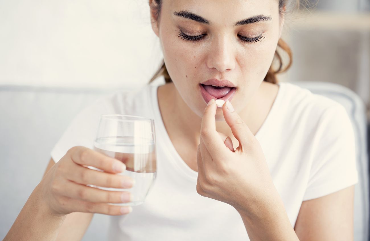 Frau die Tabletten zu sich nimmt