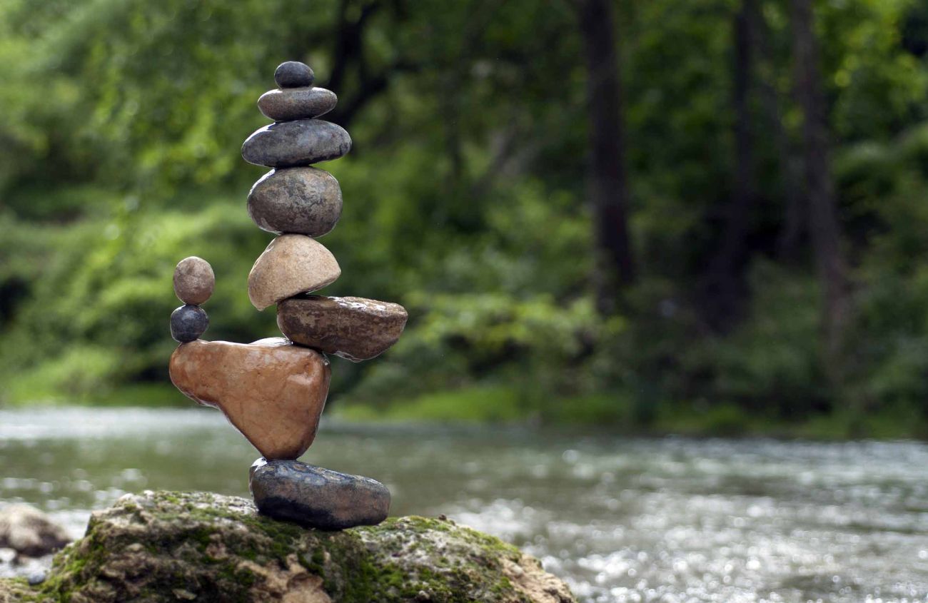 Skulptur aus glatt geschliffenen Steinen an einem Fluss