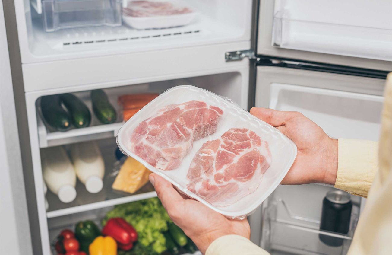Durchfall morgens nach Aufstehen, Mann bringt rohes Fleisch in den Kühlschrank