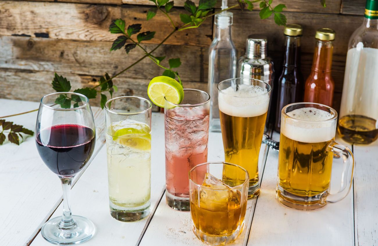Magenschonendes Essen: Verschiedene Alkoholsorten wie Wein, Bier und Whiskey auf einem Tisch.