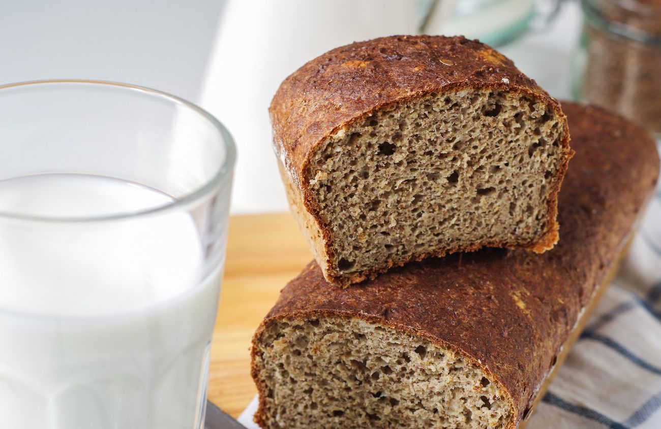 Flohsamenschalen zum Abnehmen: Ein angeschnittenes Laib Brot und ein Glas Milch