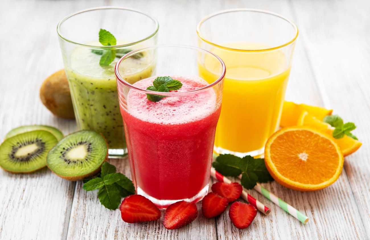 Gesunde Frucht-Smoothies und frische Früchte auf einem alten Holztisch
