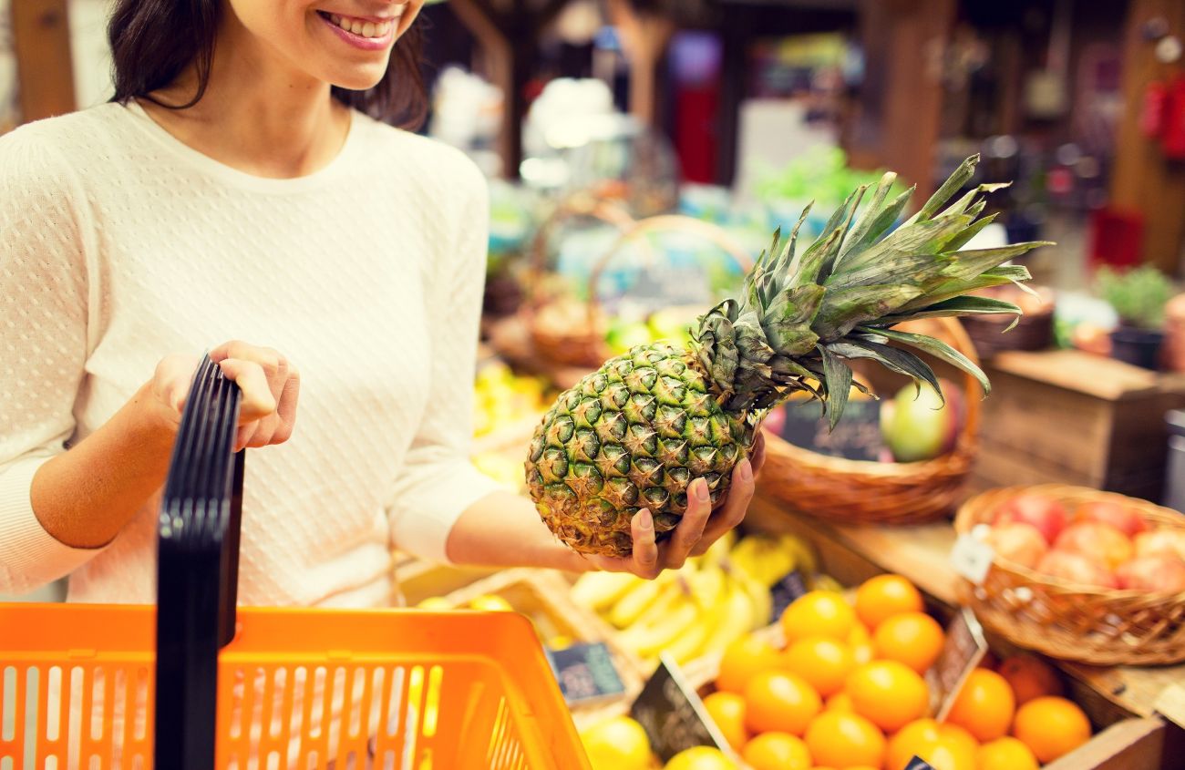 Hausmittel gegen Gastritis, Frau kauft Ananas im Supermarkt