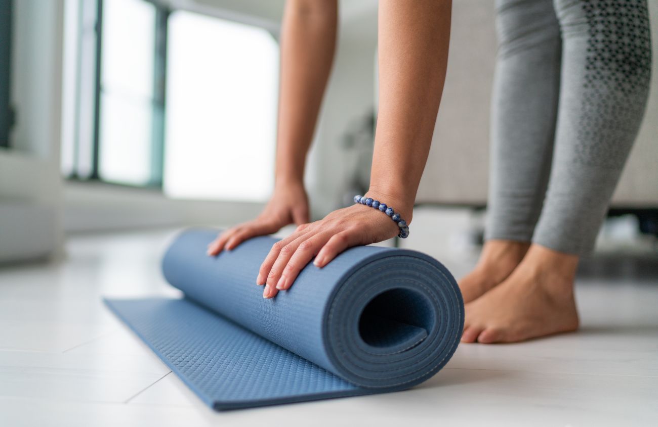 Eine Yogamatte die eingerollt wird.