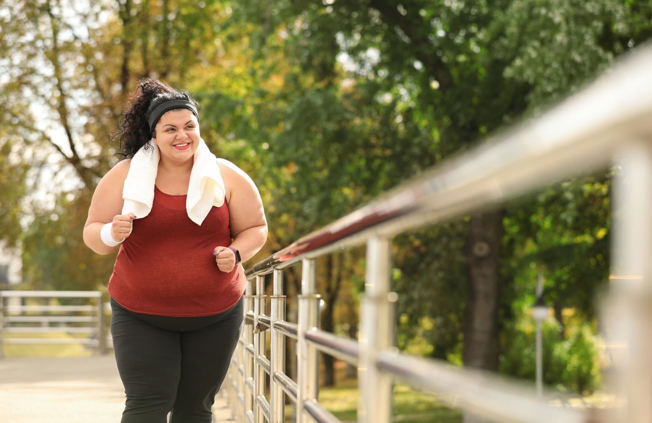 Hilft beim Abnehmen, Übergewichtige Frau joggt im Freien