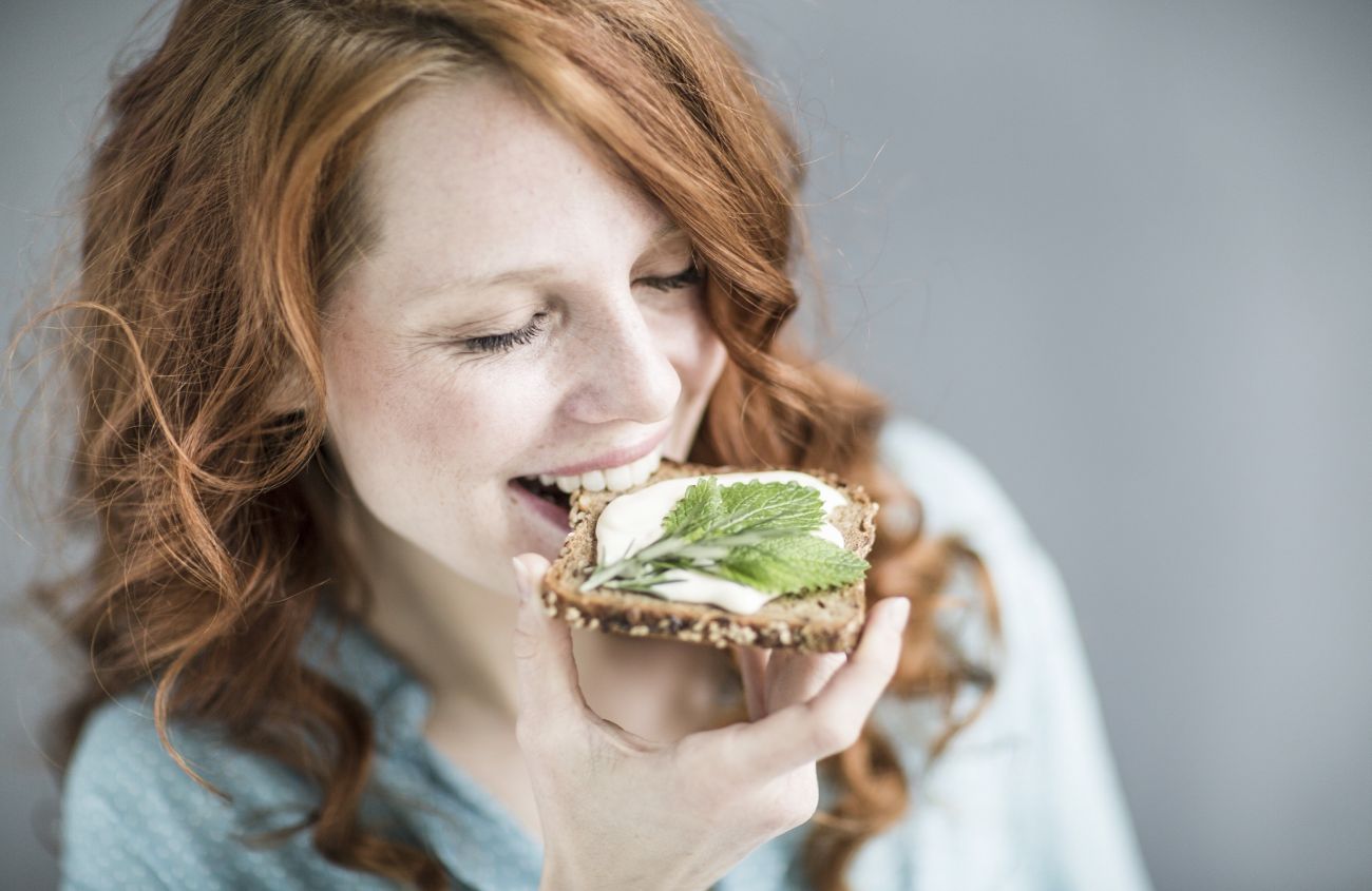 Gesunde Ernährung statt Nahrungsergänzungsmittel, Frau beißt in ein Vollkornbrot