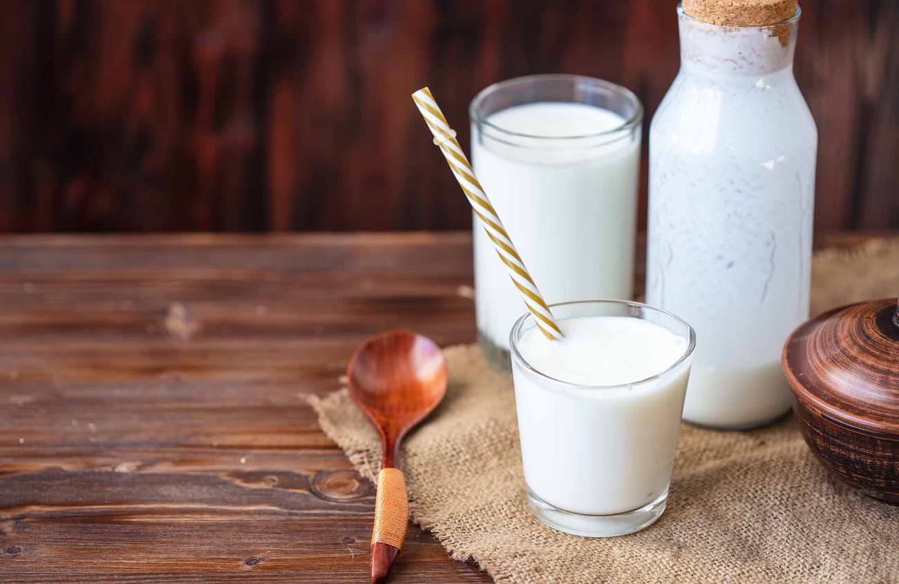 Selbstgemachter Kefir, Joghurt mit Probiotika in einem Glas auf einem Holztisch. Probiotisch gegorenes Milchgetränk.
