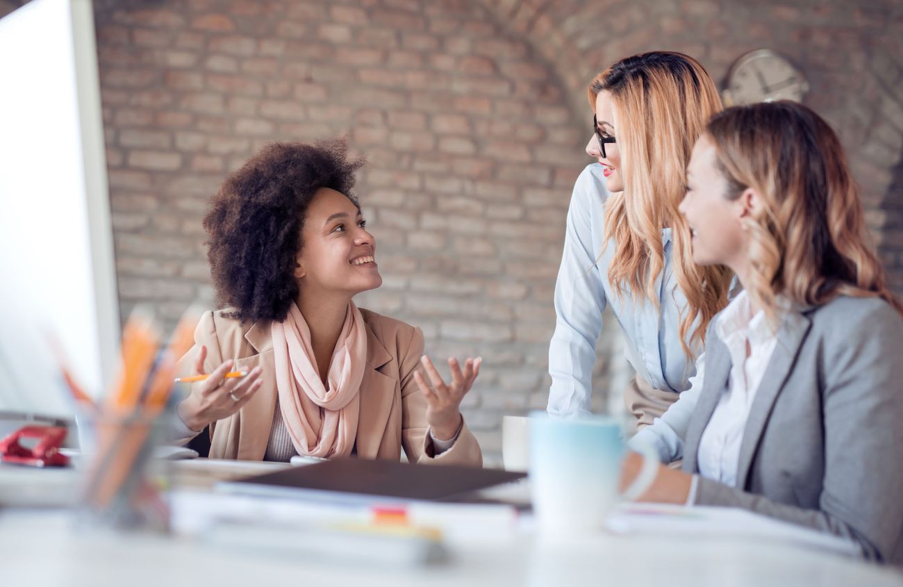 Drei Frauen besprechen sich in einem Meeting.