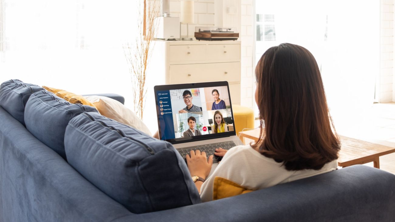 Sport und Verdauung, Frau sitzt auf Sofa und nimmt mit ihrem Laptop an einer Videokonferenz teil