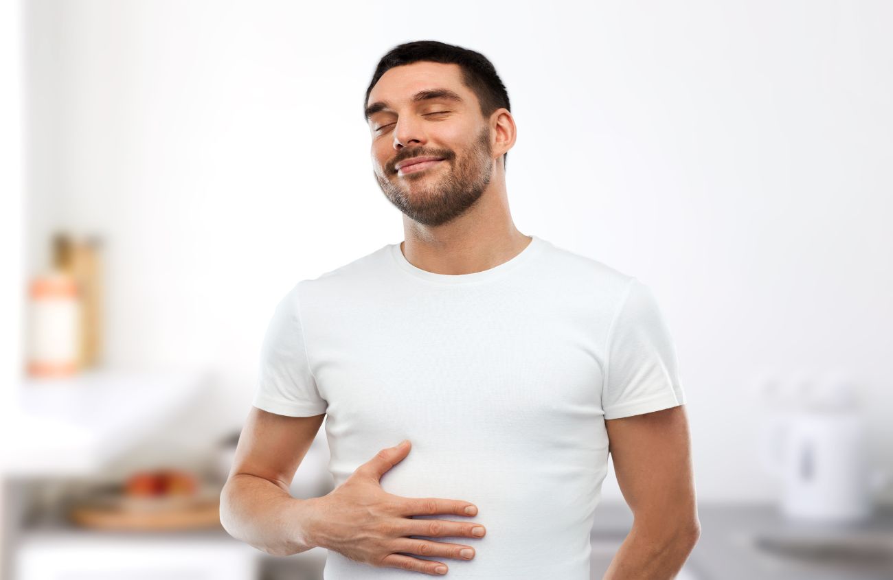 Ein Mann der seinen Bauch streichelt