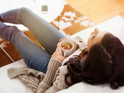 Hausmittel gegen Bauchschmerzen, Frau trinkt Kräutertee