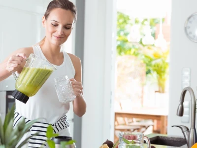 Basenfasten-Rezepte: Frau mit grünem Smoothie