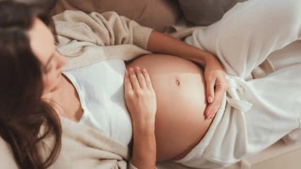 Verdauungsprobleme in der Schwangerschaft, schwangere Frau hält sich den Bauch