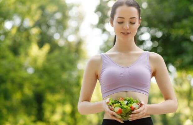 Magenschonendes Essen: Junge Frau mit einer Schale Salat in den Händen.