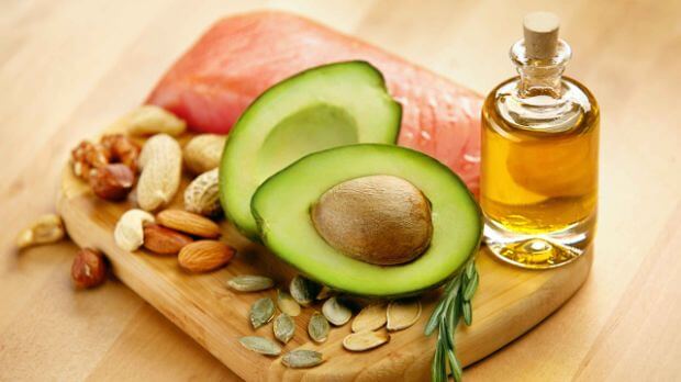 Fettverdauungsstörung und Fettstuhl, Avocado, Lachs und Nüsse auf einem Brett